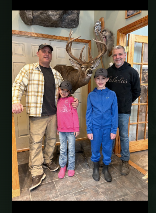 Family standing with the mounted Election Day Buck